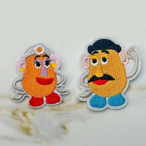 May include: Two embroidered iron-on patches of Mr. and Mrs. Potato Head from the Toy Story movie. The patches are on a white background.