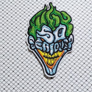 May include: Embroidered patch featuring a stylized Joker face with green hair, blue face, and a yellow grin. The patch reads "SO SERIOUS?" in a playful font, outlined in black and white.