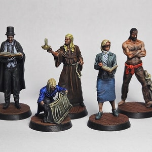 May include: Five painted miniature figures, each standing on a round wooden base. The figures are dressed in various attire, including a black coat and top hat, a brown robe, a blue jacket, a blue dress, and a red sash. The figures are holding various objects, including a book, a candle, a scroll, and a rope.