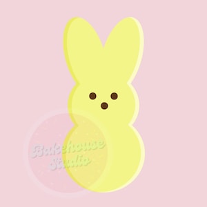 May include: A yellow bunny-shaped marshmallow candy with brown eyes. The candy is on a pink background.