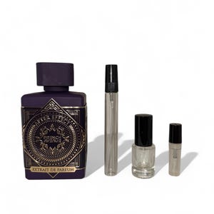 May include: A collection of perfume bottles and vials. The largest bottle is dark purple with gold lettering and a square shape. The smaller vials are clear with black caps. The text "AFTER EFFECT" and "FRENCH AVENUE" is visible on the largest bottle.