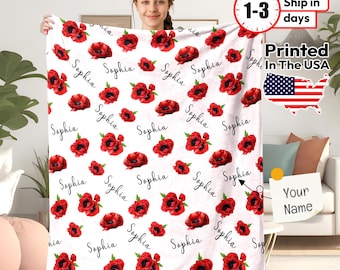 May include: White fleece blanket with a red poppy floral pattern and the name "Sophia" repeated throughout. The blanket is personalized with the option to add a name.