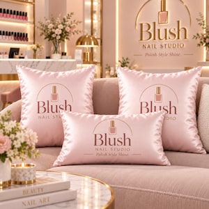 May include: Three light pink satin throw pillows featuring the Blush Nail Studio logo and the text Polish Style Shine. The pillows are arranged on a sofa, displaying a smooth, reflective fabric finish with dark brown printed branding.