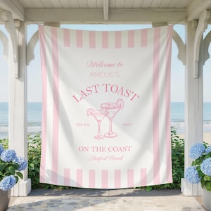 以下が含まれることがあります： ピンクのストライプと「Welcome to Amelie's Last Toast」の文字が入った白いバナー。2つのカクテルのグラフィックがあります。バナーには「On the Coast Beaufort Beach」と日付「SEP 6-9 2025」も含まれています。