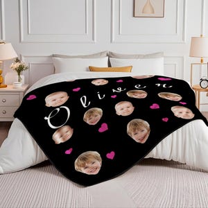 May include: Black fleece blanket with a repeating pattern of a child's face and pink hearts. The blanket has the name "Oliver" written in white cursive letters.