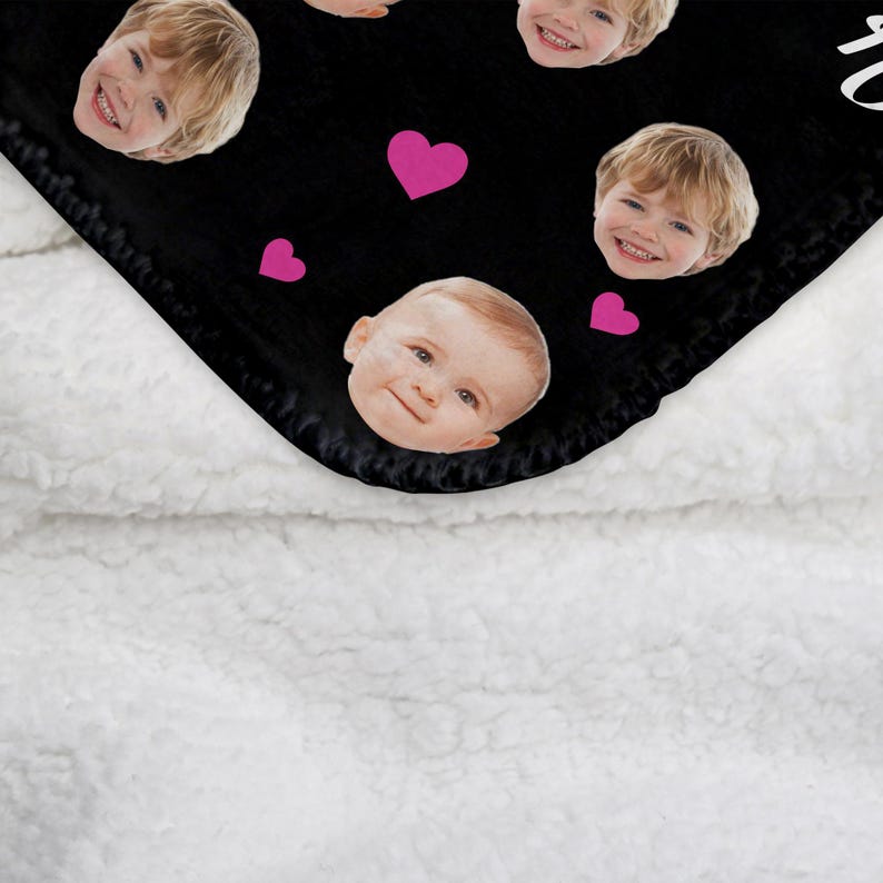 May include: Black fleece blanket with multiple images of children's faces and pink hearts printed on it.