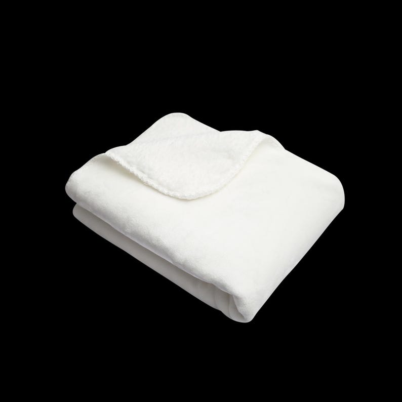 May include: A white plush blanket folded in half, showing the soft texture of the fabric.