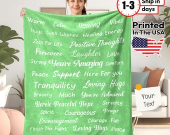 May include: Green fleece throw blanket with white text that reads "Warm, Calm, Healing, Vibes, Hugs, Well Wishes, Healing Energy, Zest For Life, Positive Thoughts, Persevere, Laughter, Love, Strong, You're Amazing, Comfort, Peace, Support, Here For You, Tranquility, Loving Hugs, Bravery, Much, You're Admired, Heroic, Peaceful Hope, Serenity, Spirit, Courageous, Prayer, Encouragement, Courage, Fun, Finish The Fight, Loving Hugs, Peace".