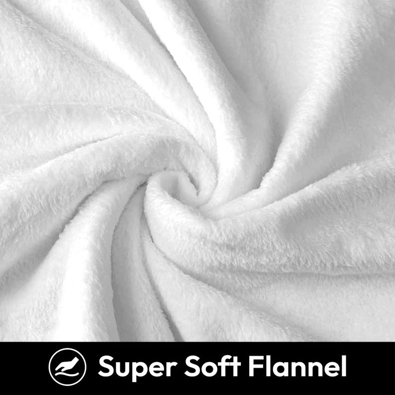 May include: Close-up of a white, soft, plush blanket. The blanket is made of flannel and has a smooth, velvety texture.