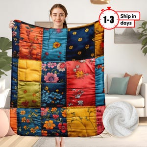 May include: A patchwork quilt throw blanket with a floral pattern in shades of yellow, red, blue, and green. The quilt is made of different fabrics and has a quilted texture.