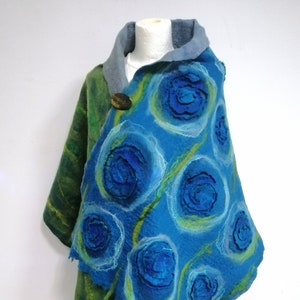 Peut inclure: Un châle en laine feutrée bleu et vert avec un motif décoratif de fleurs bleues. Le châle a une bordure frangée et une fermeture à bouton.