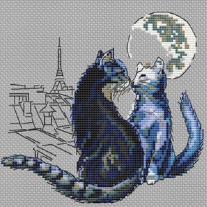 Könnte beinhalten: Kreuzstichmuster mit zwei blauen Katzen, die sich unter einem Halbmond mit einer Stadtlandschaft im Hintergrund küssen, einschließlich des Eiffelturms.