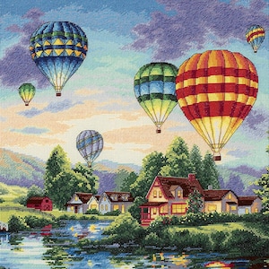 Puede incluir: Una pintura colorida de un paisaje rural con un lago y casas. El cielo está lleno de globos aerostáticos de varios colores y patrones, incluyendo azul, rojo, amarillo y verde.