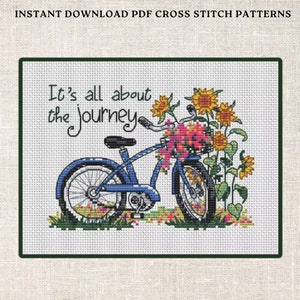 May include: Cross stitch pattern featuring a blue bicycle with a basket of flowers and sunflowers. The text "It's all about the journey" is written in a whimsical font.
