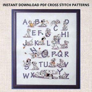 Puede incluir: Patrón de punto de cruz con el alfabeto y cachorros dálmatas. Cada letra está representada por un cachorro en una pose diferente. El patrón está enmarcado en un marco azul.