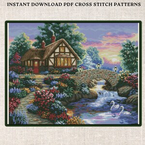 May include: A cross stitch pattern depicting a cottage with a thatched roof, a stone bridge over a stream, and swans swimming in the water. The scene is set in a lush garden with colourful flowers.