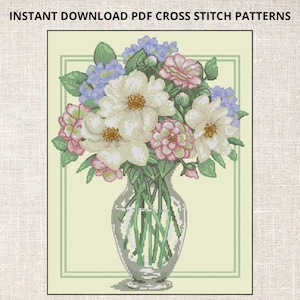 Może przedstawiać: Wzór do haftu krzyżykowego przedstawiający bukiet białych, różowych i niebieskich kwiatów w przezroczystym szklanym wazonie. Kwiaty są ułożone symetrycznie i otoczone zielonymi liśćmi. Wazon stoi na jasnozielonym tle.