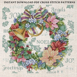 Op de afbeelding: Een kruissteekpatroon met een kerstkrans met rode, roze en witte kerststerren, groene hulst en een gouden trompet. De krans is versierd met een paars en wit lint en de woorden "Joy", "Noel", "Greetings", "Angels" en "Jingle Bells" staan rond de krans.