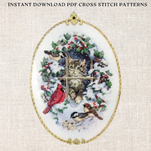 May include: A cross stitch pattern featuring a cat peeking out of a window with snow and birds. The pattern is framed in a gold oval with a decorative top.