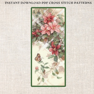 May include: Cross stitch pattern featuring a delicate pink flower with green leaves and a butterfly. The pattern is framed in a green border.
