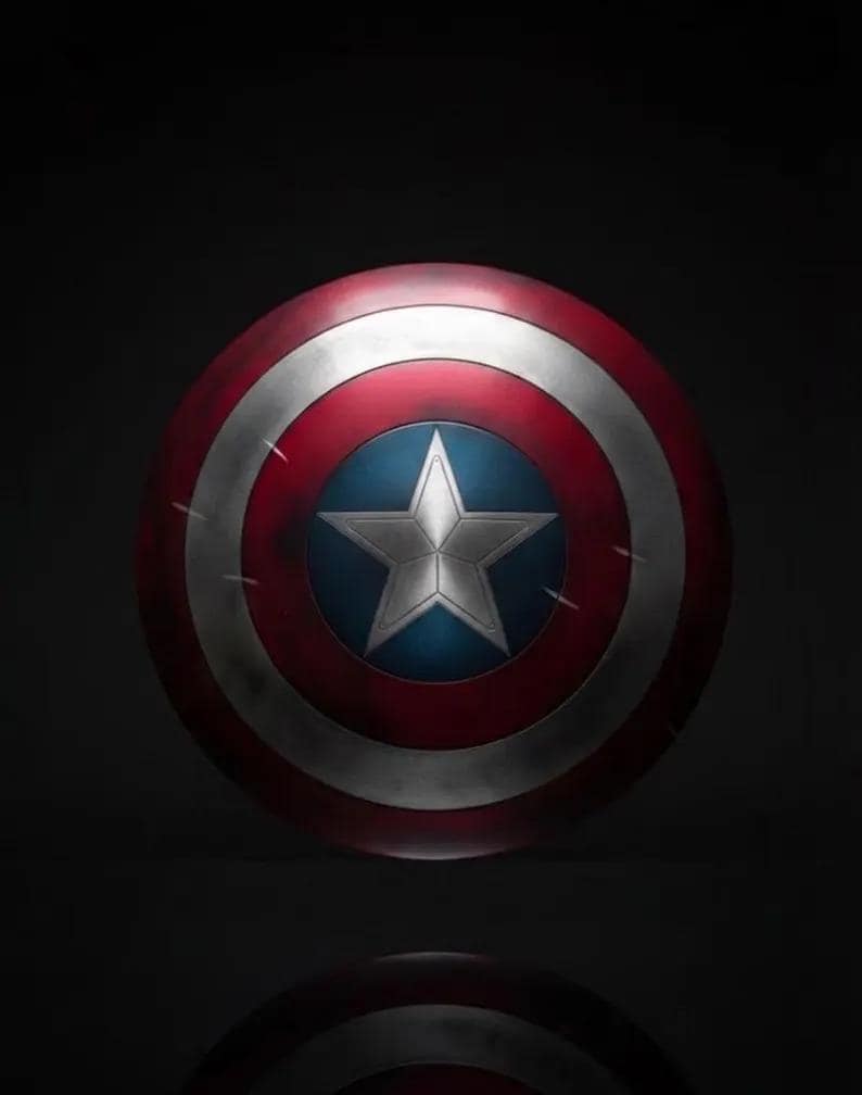 May include: A round shield with a red, white, and blue color scheme. The shield features a white star on a blue circle in the center, surrounded by white and red concentric rings. The shield has a metallic appearance.