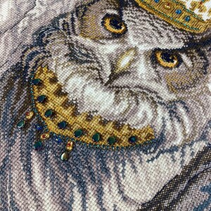 Finished owl bird cross stitch artwork framed as elegant wall décor, detailed needlework with beads.