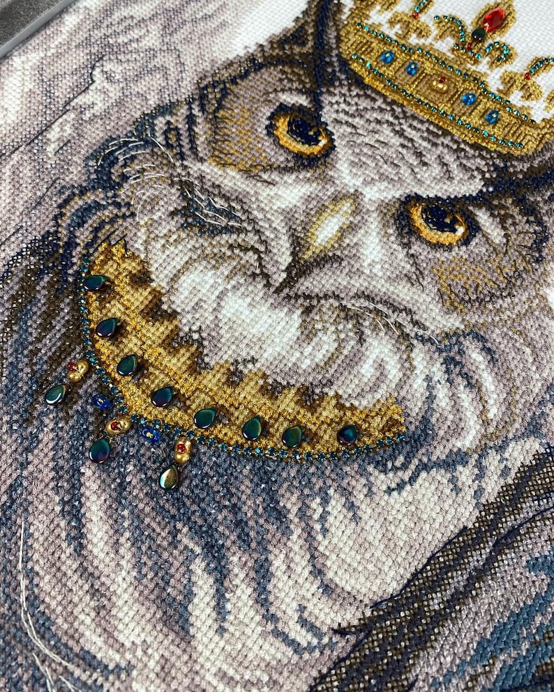 Finished owl bird cross stitch artwork framed as elegant wall décor, detailed needlework with beads.