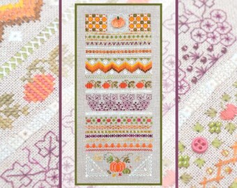 May include: A rectangular cross-stitch sampler on light beige fabric featuring horizontal bands of autumn-themed motifs including orange pumpkins, green leaves, purple grapes, and geometric patterns in shades of orange, yellow, green, and purple.