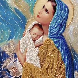 May include: A beaded artwork depicting the Virgin Mary holding the baby Jesus. Mary is wearing a blue beaded robe and a gold beaded dress. Jesus is wrapped in a white beaded cloth. The background is a blue and white beaded design.