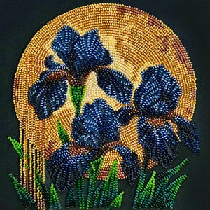 Pode incluir: Uma obra de arte em contas com flores de íris azuis com caules e folhas verdes, em um fundo dourado semelhante ao sol. A peça está em um fundo escuro, mostrando o trabalho detalhado em contas.