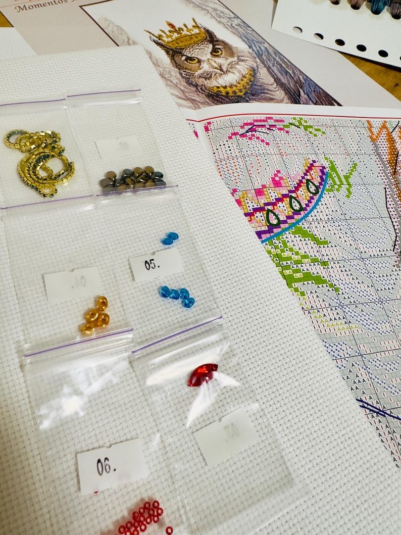 Cross stitch kit contents including Aida fabric, Madeira floss, Czech beads, needles and printed chart.