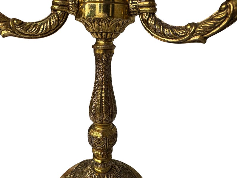 Pu&ograve; includere: Candelabro dorato ornato con tre bracci curvi. Il candelabro presenta dettagliati motivi floreali e a foglie. La base &egrave; rotonda e presenta un motivo in rilievo. Lo stile generale &egrave; vintage e decorativo. Il candelabro &egrave; in metallo.
