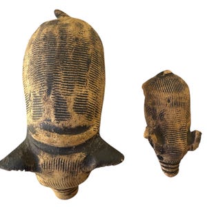 Pu&ograve; includere: Due sculture in ceramica marrone e nera. La scultura pi&ugrave; grande ha una forma a testa con una base larga e una piccola pinna sulla parte superiore. La scultura pi&ugrave; piccola ha un design simile, ma &egrave; pi&ugrave; piccola e pi&ugrave; arrotondata.