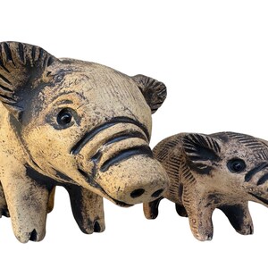 Pu&ograve; includere: Due statuette di maiale in ceramica. Il maiale pi&ugrave; grande &egrave; marrone chiaro con accenti marrone scuro, e il pi&ugrave; piccolo ha una colorazione simile. Entrambi hanno dettagli, tra cui orecchie, musi e occhi. Sono oggetti decorativi.