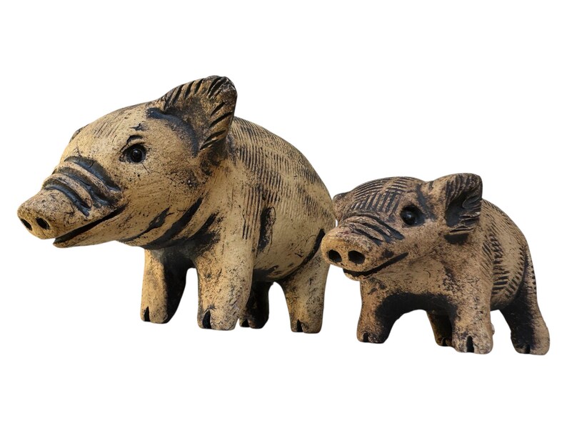 Pu&ograve; includere: Due statuette di cinghiali in ceramica. Il cinghiale pi&ugrave; grande &egrave; beige con strisce e dettagli marrone scuro. Il cinghiale pi&ugrave; piccolo ha una colorazione e dettagli simili.
