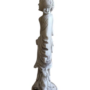 K&ouml;nnte beinhalten: Eine wei&szlig;e Statue einer Figur in flie&szlig;enden Gew&auml;ndern, die auf einem runden Sockel mit einem dekorativen Muster steht. Die Statue ist mit komplizierten Details geschnitzt, die den ruhigen Ausdruck und die elegante Kleidung der Figur zeigen. Die Statue ist ein dekorativer Gegenstand.