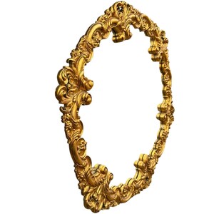 May include: Ornate gold-colored oval frame with detailed scrollwork and floral accents. The frame has a three-dimensional design and is set against a white background. The frame is likely for a mirror or artwork.