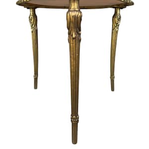 May include: A small, antique side table with a round, wooden top and three ornate, gold-coloured legs. The legs have a fluted design and decorative accents. The table is likely made of metal and wood.