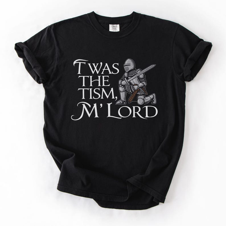 May include: Black t-shirt with a white graphic of a knight kneeling with a sword and the text "Twas the tism, M'Lord".