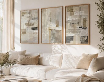 May include: Three framed abstract art pieces in neutral tones hang above a white sectional sofa. The artwork features a mix of beige, gray, and black rectangular shapes. The living room also includes a wooden coffee table and decorative pillows.