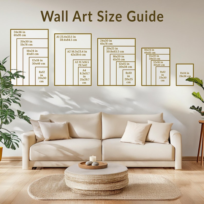 Cozy Japandi-style living room with a neutral-toned sofa, woven coffee table, and green houseplants. A framed "Wall Art Size Guide" is displayed on the beige wall, showcasing standard art print sizes in a modern, serene home setting.