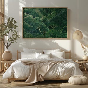 A cozy bedroom with a white bed, beige blankets, and pillows, sits under a large green forest painting. Natural light, plants, and textures add warmth.