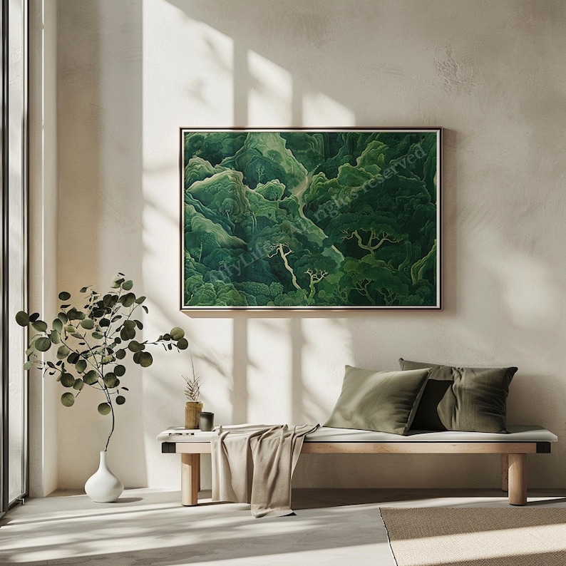A serene, minimalist living space with a large, framed green forest painting on a light wall. Sunlit bench with green cushions, small plant in white vase.