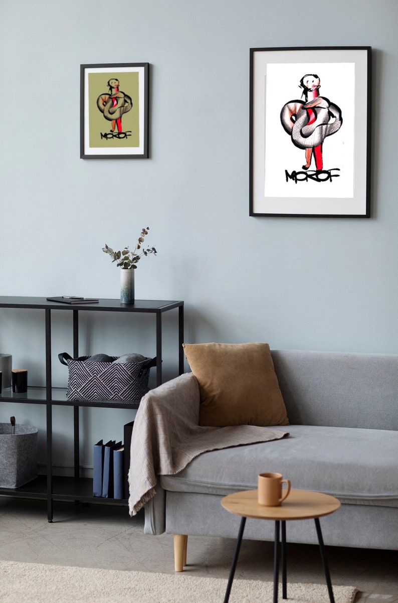 May include: Two framed illustrations of a person with a snake wrapped around them. The illustrations are in black and white with red accents. The text "MOROF" is written in black below the person in both illustrations. The illustrations are hanging on a light blue wall.