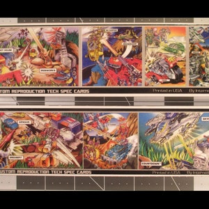 May include: Two sets of vintage trading cards featuring colorful illustrations of robots and vehicles in action scenes. The cards are labeled "1989 Custom Reproduction Tech Spec Cards" and printed in the USA by InternetRebellion.