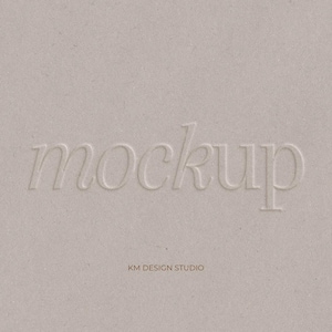 Könnte beinhalten: Nahaufnahme einer strukturierten, hellbeigen Oberfläche mit dem Wort "mockup" in einem zarten, serifenbetonten Schriftzug geprägt. Darunter steht der Text "KM DESIGN STUDIO".