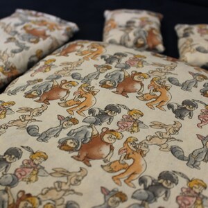 Puede incluir: Un conjunto de cuatro almohadas con un fondo blanco y un patrón repetido de personajes de dibujos animados de Winnie the Pooh. Los personajes incluyen Winnie the Pooh, Piglet, Eeyore, Tigger y Rabbit.