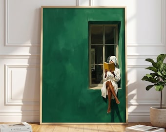 May include: A framed art print depicts a person in a white robe and towel reading a yellow book while sitting in a window. The wall is painted a deep green, and the frame is gold. A small potted plant and books are in the foreground.