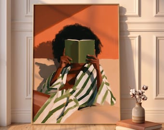 May include: A framed wall art print depicting a person with dark curly hair wearing a white and green striped robe, holding an open green book in front of their face. The background features warm orange tones and soft shadows in a painterly style.