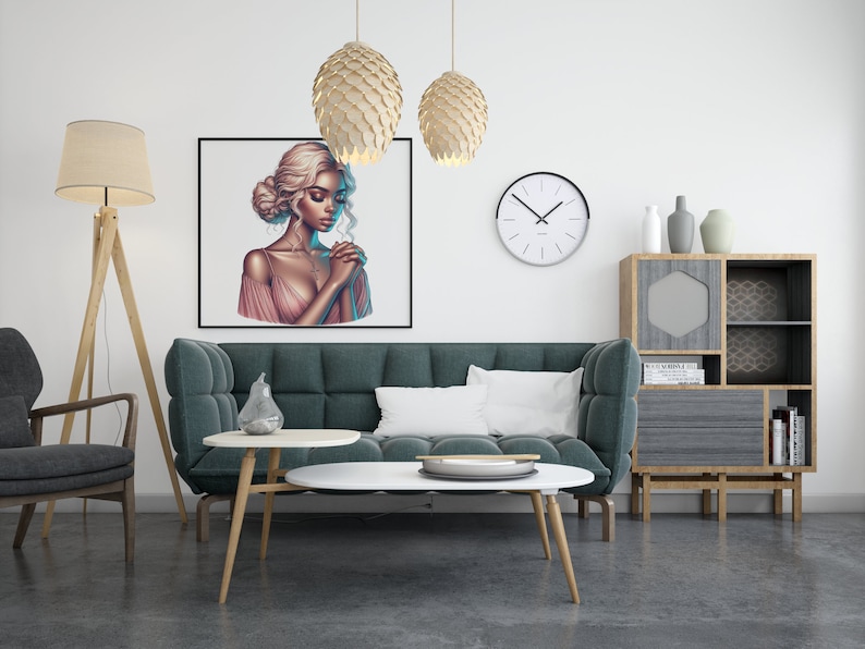 May include: A teal green sofa with a white pillow in a living room setting. A framed print of a woman with long blonde hair wearing a pink dress hangs on the wall above the sofa. There are two hanging light fixtures with a wood-like finish and a floor lamp with a beige lampshade. A wooden shelf with a geometric design and a small round table with a white top are also visible.